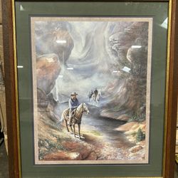 Beautiful framed print of a western scene with cowboys on horseback. Signed by J. Morgan Crain. Brown wooden frame with green mat and gold border. Beh