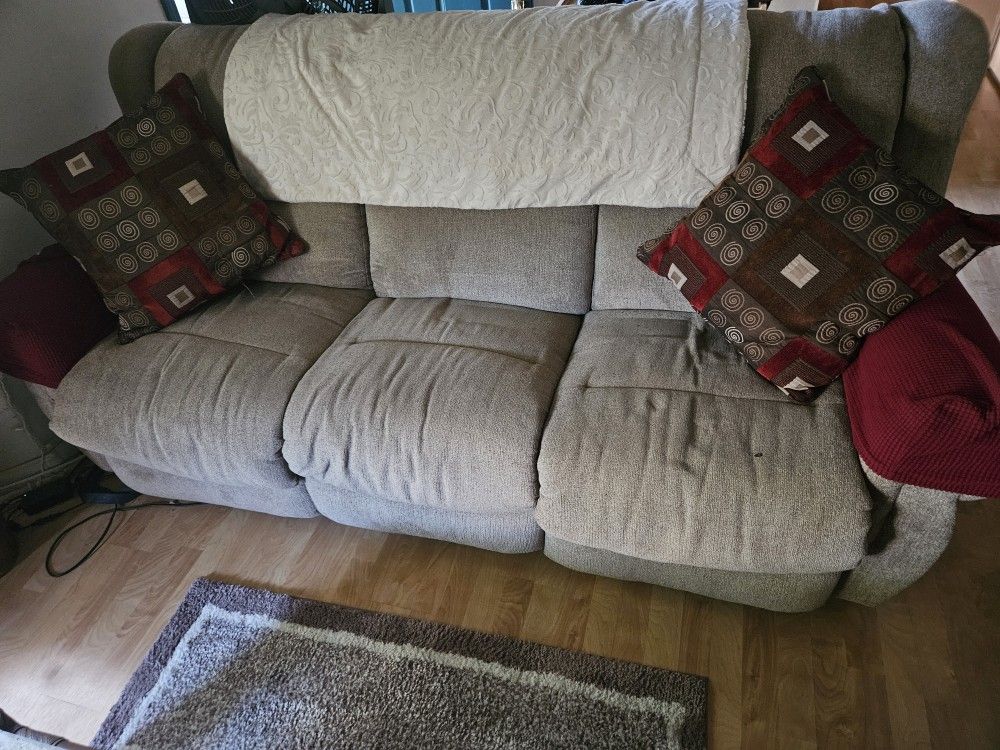 Beige power reclining couch and matching power recliner.