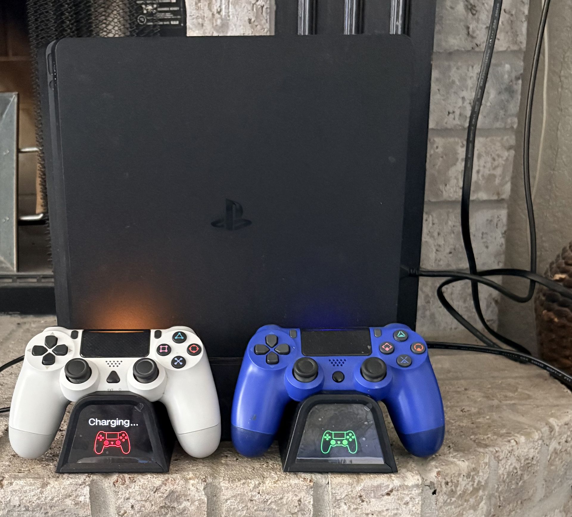 PS4 with two remotes with a charging stand