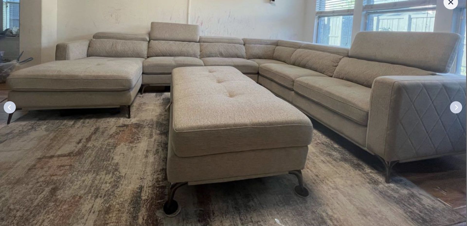 Spacious 7-seater light beige sectional sofa with ottoman and soft rug