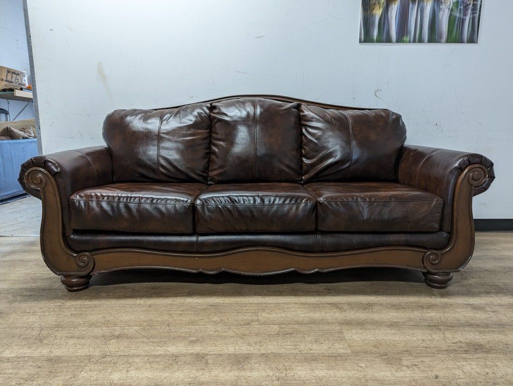 Ashley Brown Bonded Leather Couch with Wood Trim