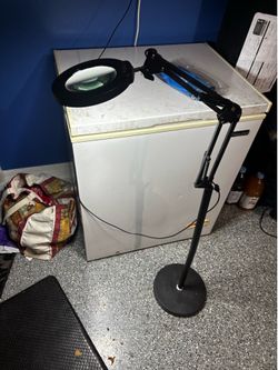 Adjustable floor lamp with a built-in magnifying lens and LED ring light