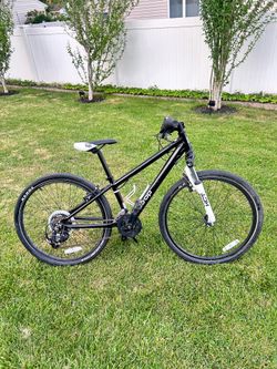black Co-op Cycles REV 24 kids' bike features a lightweight aluminum frame and front suspension.