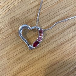 Ruby, tourmaline, and Jasper stones in pendant with silver cord.