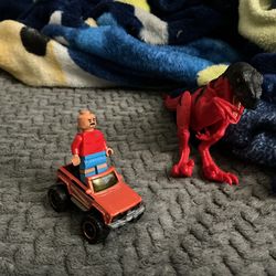 A car with a toy Lego person  and a toy dinosaur