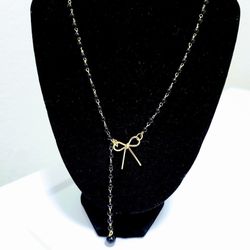 Tie Bow Pendant Necklace features a delicate gold-plated bow design