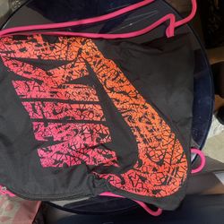 black Nike drawstring gym sack bag with a pink and orange graphic logo and straps