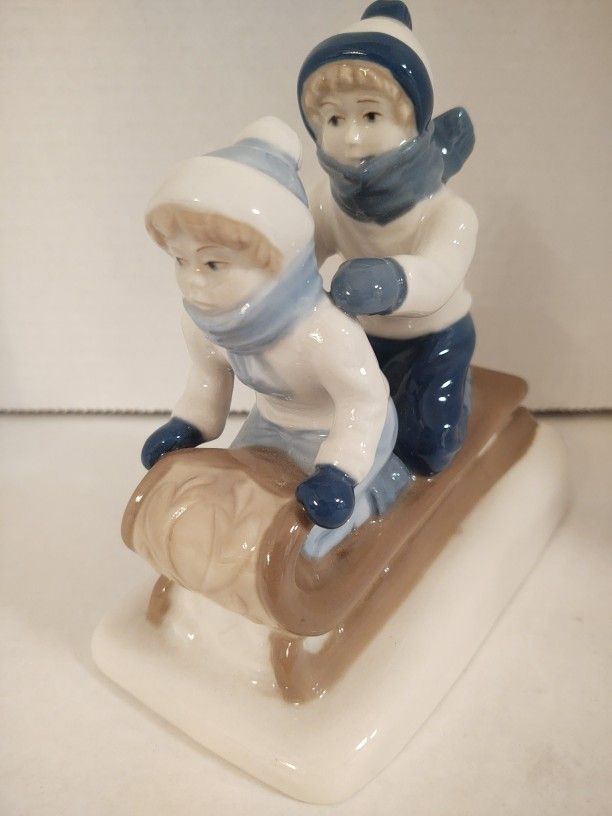 Vintage blue and white Porcelain two kids sledding figurine Made In Mexico