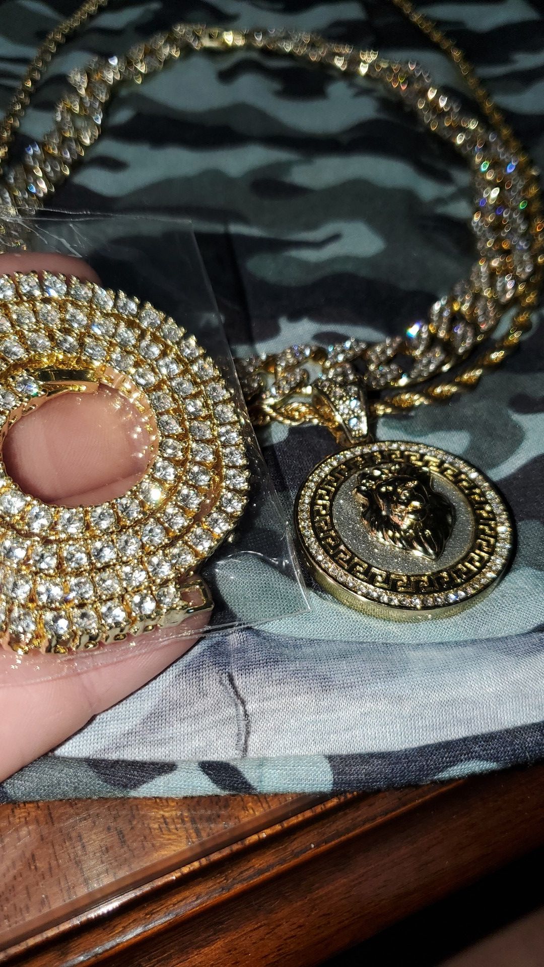 Gold iced out cuban link chain, rope chain with lion pendant, and tennis bracelet