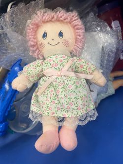 vintage plush rag doll with pink yarn hair, teardrop blue eyes, and a floral green dress with lace trim, resembling a Cuddle Wit Precious Moments styl