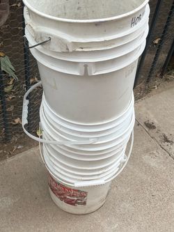 Tall Stack Of White Plastic Buckets Containers