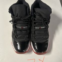 Air Jordan 11 “Bred” (Black / Red) in size 7Y (youth).