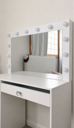 White vanity with mirror and light bulbs