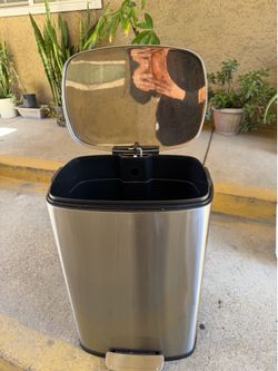 Modern stainless steel trash can with step pedal and soft-close lid.