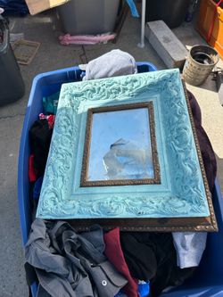 Beautiful vintage mirror is painted and blue and gold. Measurements are 9 x 12.