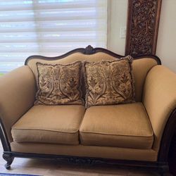 Elegant vintage sofa with ornate wooden frame and patterned cushions