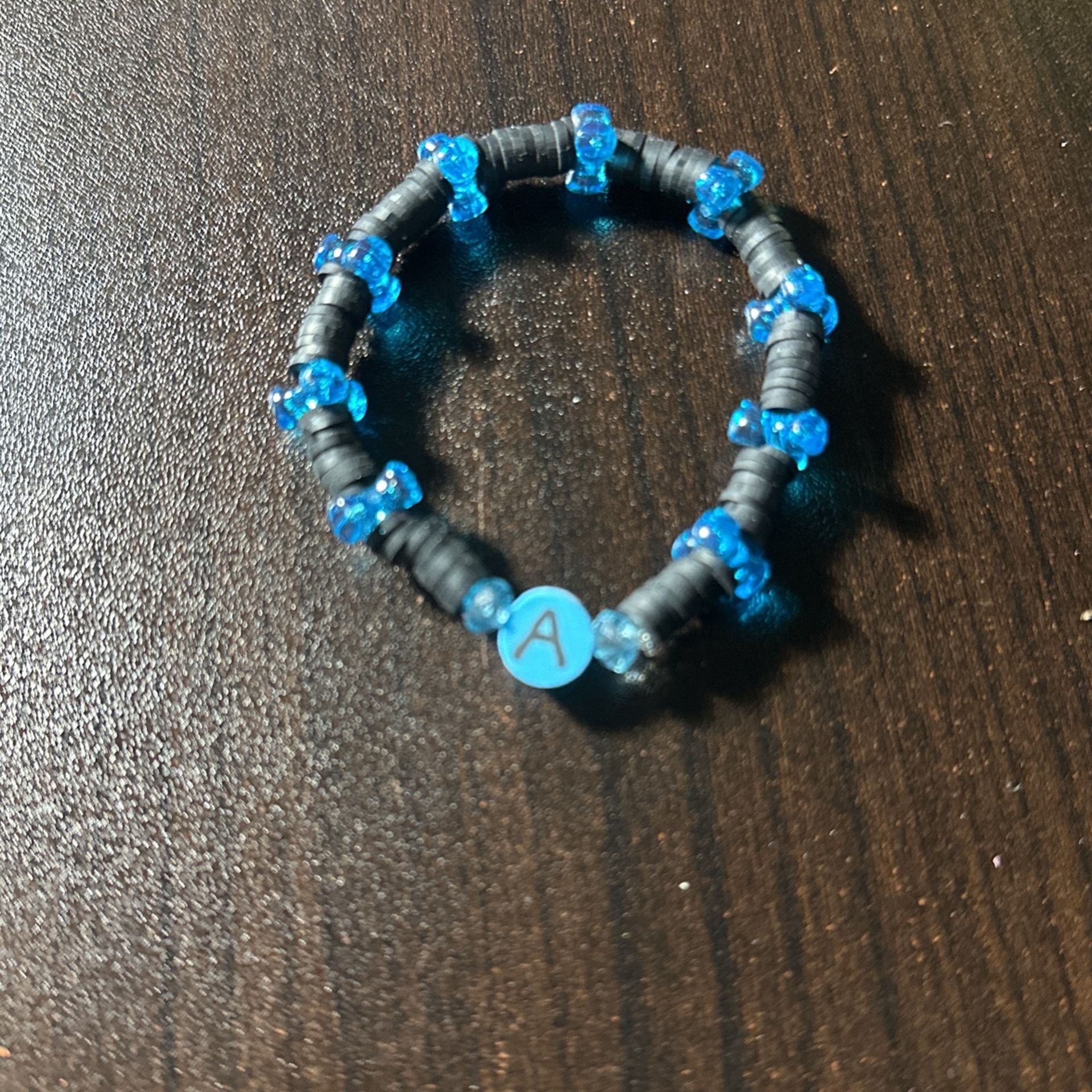 Black clay bead bracelet, with blue stars, and a letter a charm