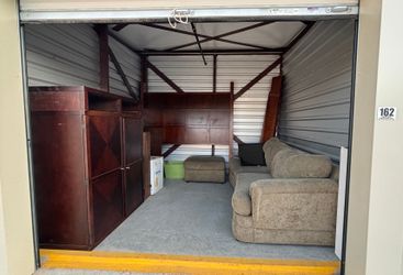 Auction Unit  162 7/13 -  Golf clubs, couch and foot cushion, TV, entertainment center, DVD's, bathroom sink