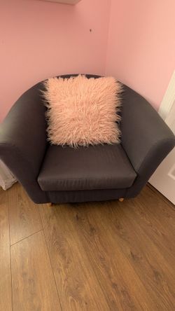 Ikea grey arm chair with pink cushion.
