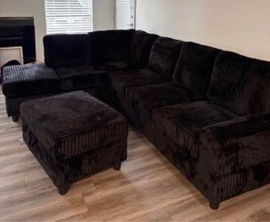 Black Corduroy Reversible Sectional with Cup Holder and Storage Ottoman. Brand New. CLEARANCE SPECIAL.