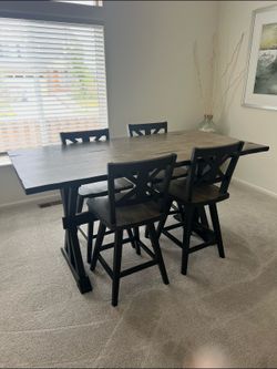 Dining room table with 4 swivel bar chairs.