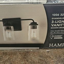 Hampton Bay
Evangeline 23 in. 3-Light
Modern Bronze Farmhouse
Bathroom Vanity Light with
Clear Seeded Glass Shades
