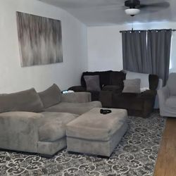 Two-seater couch accompanied by an ottoman.