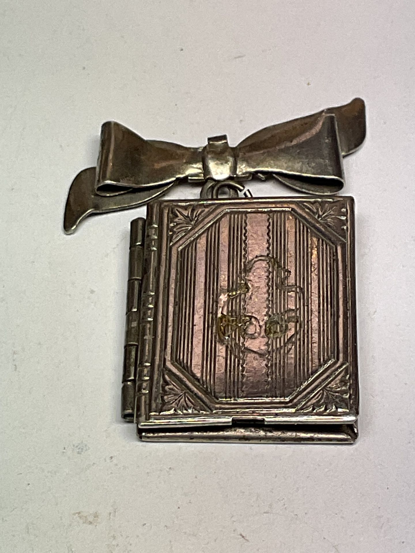 For sale is a Vintage Sterling Silver Opening Book Picture Locket Ribbon Charm.