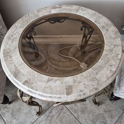 One beige stone end table, brass iron legs. In excellent condition.