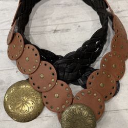 A pair of boho-style belts featuring oversized antique-gold medallions and circular leather accents.