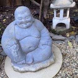 A small cement happy Buddha garden statue
