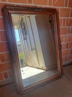 Large mirror with wood frame embellished with carved wood flowers