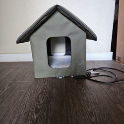 Small, green dog house with bed warmer.
