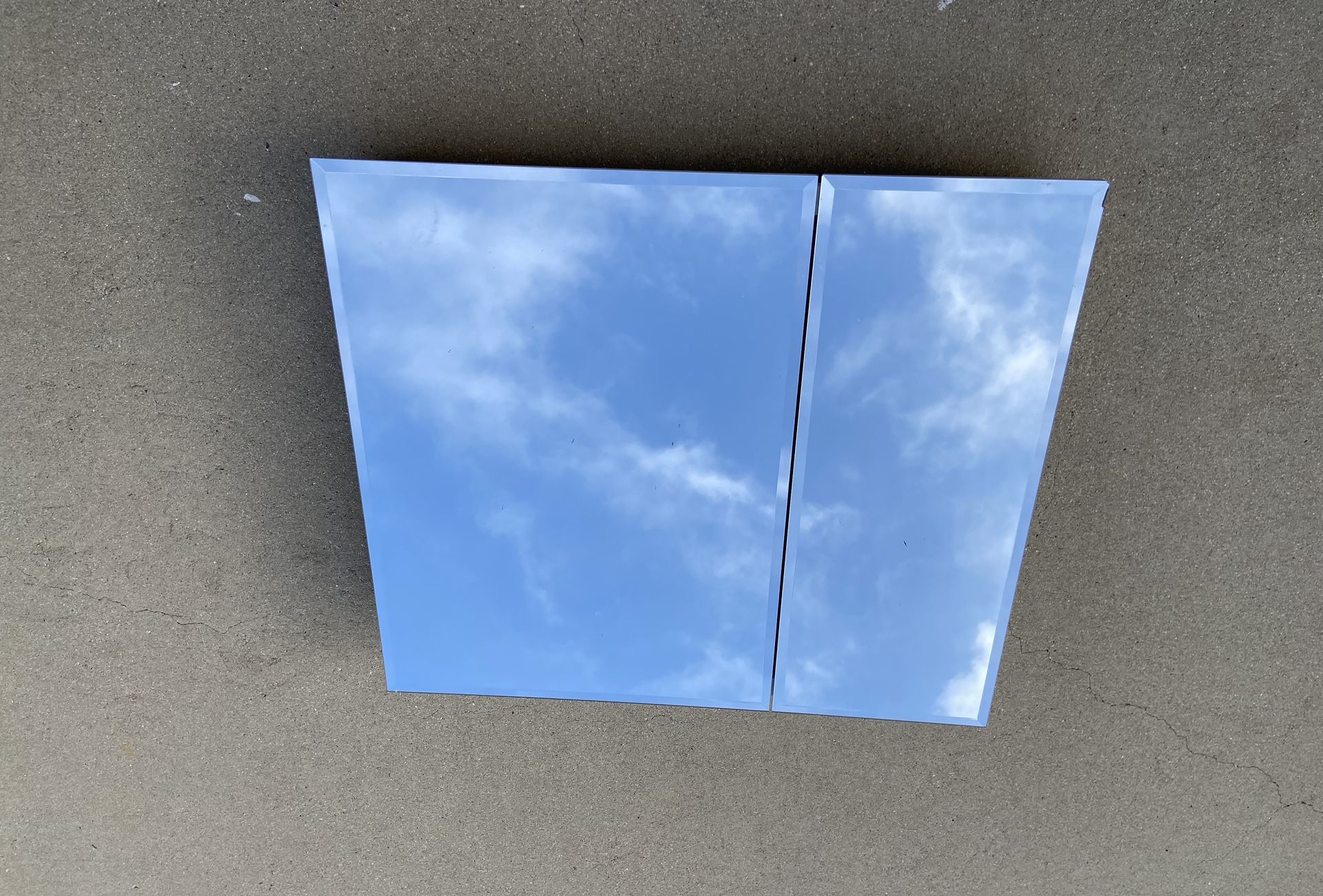 Frameless Recessed Bathroom Medicine Cabinet With Two Beveled Mirror Edged Doors.