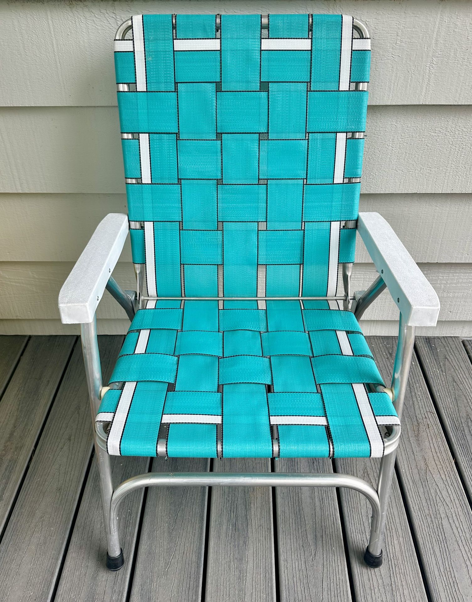 Vintage Aluminum folding webbed lawn chair. White plastic arm rests.  17” ground to the seat (off the ground ) back is ground to top 35”, and width 23