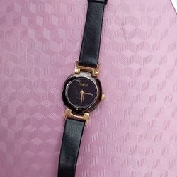 Gold-tone women's watch with diamond accent and black leather strap by Sheffield