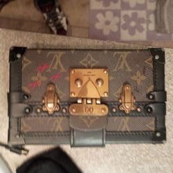Louis Vuitton Petite Malle bag featuring the iconic monogram coated canvas paired with black leather trim and gold-tone hardware