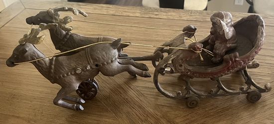 Antique cast iron reindeer pulling Santa in a sled. Toy, Christmas, metal decor 