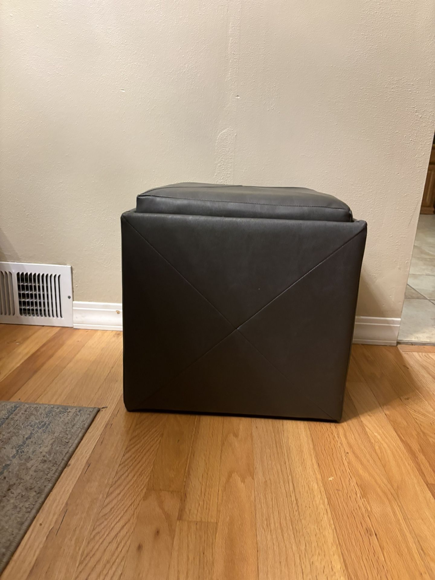 Brown faux leather storage ottoman with a reversible dark wood tray top.