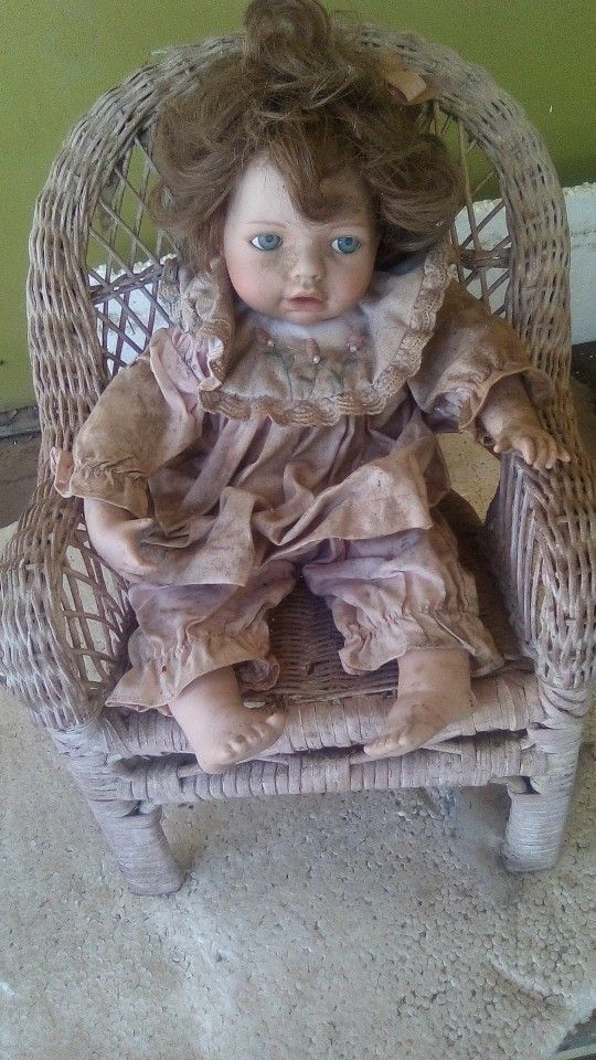 Porcelain Doll On Wicker Chair 
