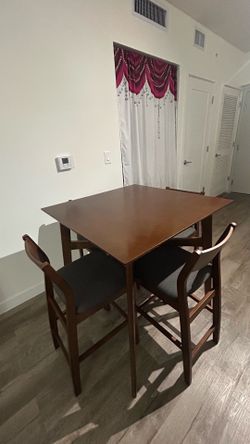 Mesa de comedor con 4 sillas altas.