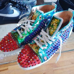 This is a pair of Christian Louboutin Lou Spikes high-top sneakers in a multi-color floral print with assorted metal spikes. 