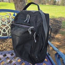 Black nylon back pack with wheels and pull out handle.