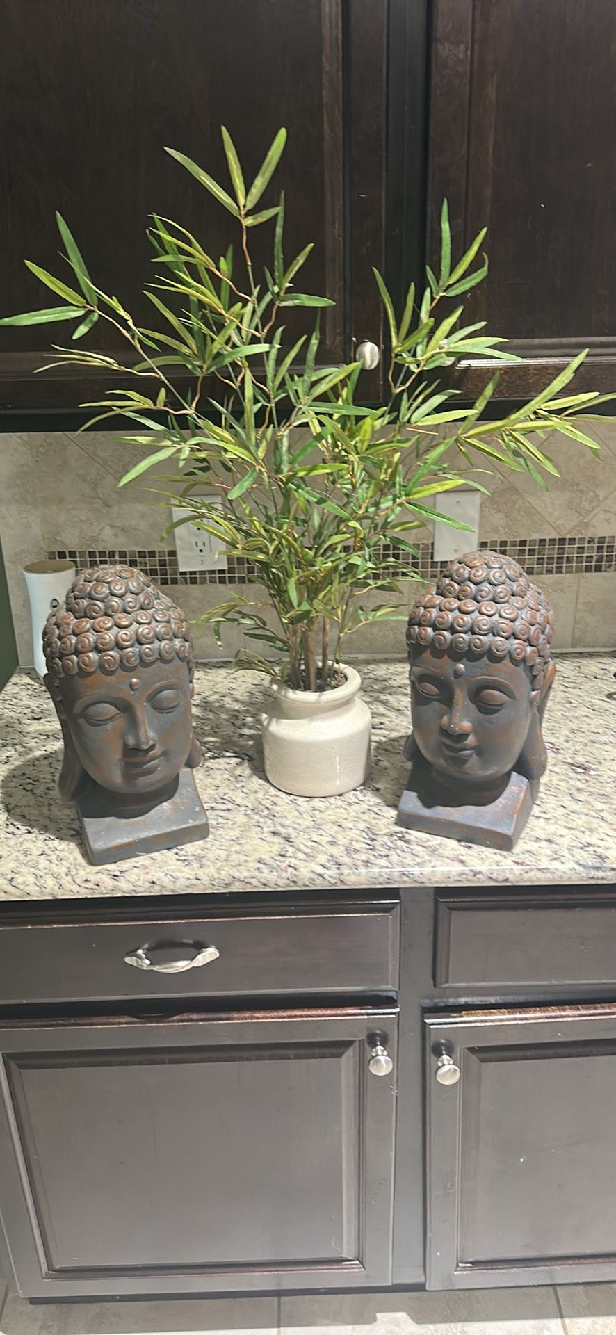 Two Buddha heads and bamboo plant