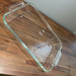 Pyrex clear glass baking dish, designed with integrated handles for safe handling.