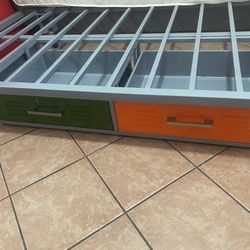 Gray iron bed in very good condition with an orange drawer and a green drawer with plenty of space to store things. It has 4 wheels to be able to move