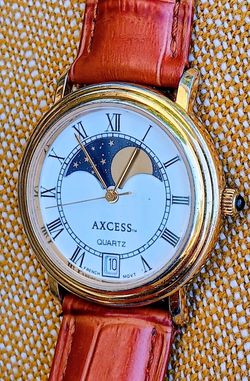 Wonderful vintage French quartz watch by Axcess, featuring a moon phase and date display, in a gold tone.