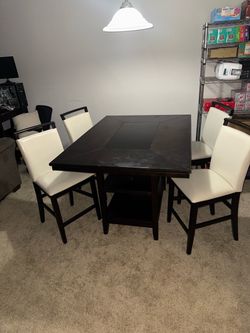 Large wooden table with dark glass inlay and 4 leather chairs