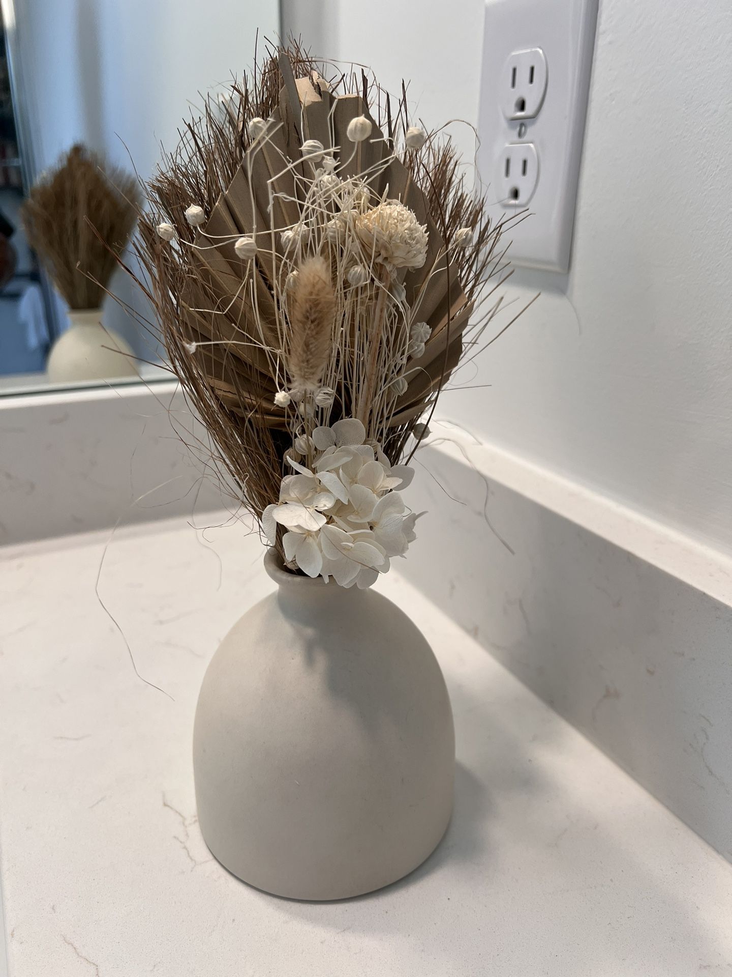 Dried floral arrangement in a neutral ceramic vase