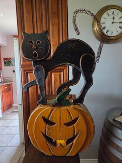 Black cat 🐈‍⬛️ on jack-o-lantern wooden pumpkin 🎃